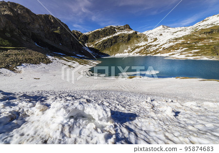 Alpine emerald lake and mountains at springtime, Gran Paradiso Alps, Italy 95874683