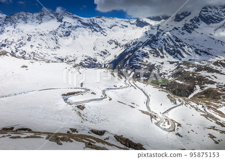 Alpine mountain road between snow at springtime, Gran Paradiso Alps, Italy Alpine mountain road between snow at springtime, Gran Paradiso Alps, Italy 95875153