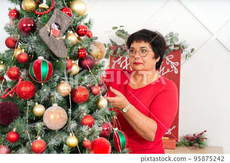 Woman decorating beautiful Christmas tree at home, closeup. christmas holidays and people concept. 95875242