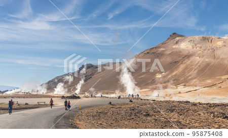 Closeup of Namafjall is Iceland popular geothermal area with a unique landscape of steaming pools and mudpots. Visitors not reccognizable. Closeup of Namafjall is Iceland popular geothermal area with a unique landscape of steaming pools and mudpots. Visitors not reccognizable. 95875408