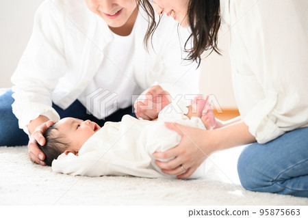 Asian mother and father soothing a baby Asian mother and father soothing a baby 95875663