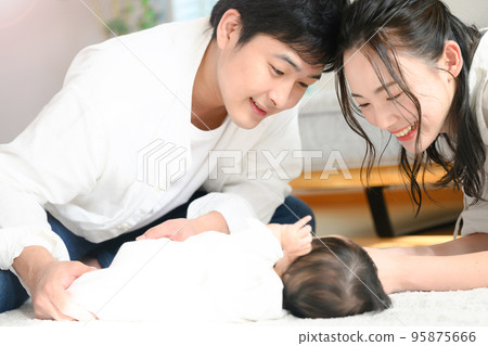 Asian mother and father soothing a baby Asian mother and father soothing a baby 95875666