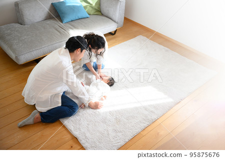 Asian mother and father soothing a baby Wide-angle bird's-eye view Copy space on the right 95875676