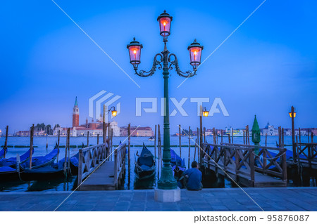 Gondole docked by wooden mooring poles in grand canal, Ethereal Venice, Italy Gondole docked by wooden mooring poles in grand canal, Ethereal Venice, Italy 95876087