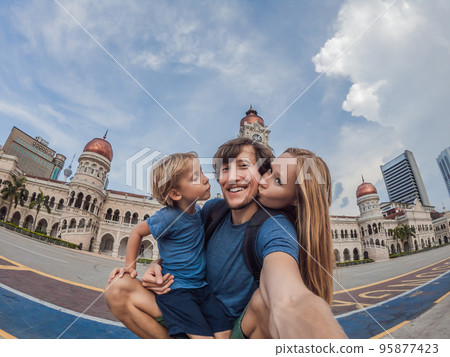 happy family makes selfie on the background on background of Merdeka square and Sultan Abdul Samad Building. Traveling with children concept 95877423