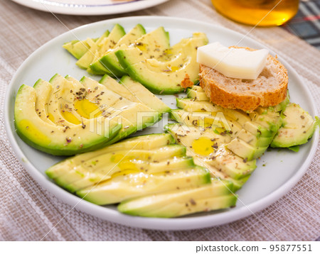 ripe avocado pulp cut into pieces sprinkled with lemon juice on a plate 95877551