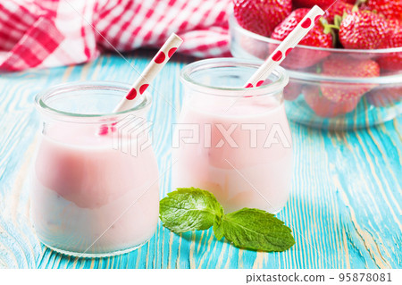 Strawberry milkshake in the glass jar on blue wooden background Strawberry milkshake in the glass jar on blue wooden background 95878081