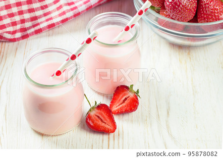 Strawberry milkshake in the glass jar on white wooden background 95878082