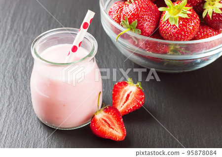 Strawberry milkshake in the glass jar on black slate background Strawberry milkshake in the glass jar on black slate background 95878084