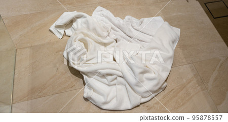 White towels lie after use on the floor of the hotel bathroom 95878557