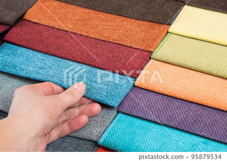 Woman hand chooses samples of colored tissue Woman hand chooses samples of colored tissue 95879534