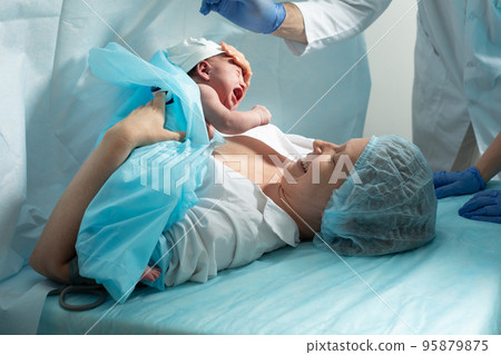Mother holds newborn baby in hospital Mother holds newborn baby in hospital 95879875