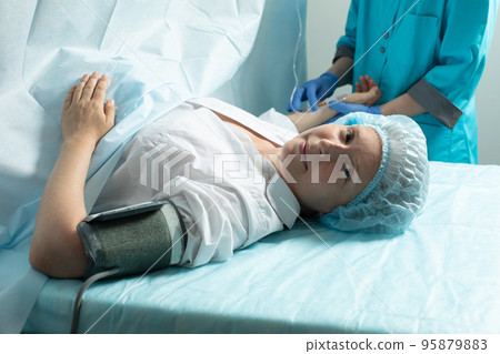 Female patient in operating room at hospital, ready to cesarean section Female patient in operating room at hospital, ready to cesarean section 95879883