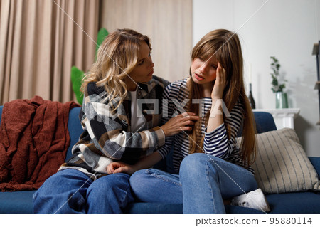 Tell me about your problems Middle age woman comforting her young daughter who sitting on the sofa Tell me about your problems Middle age woman comforting her young daughter who sitting on the sofa 95880114