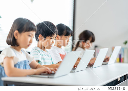Elementary school students studying on laptops. 95881148
