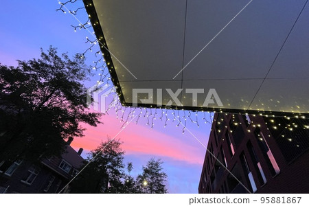 Christmas lights with setting sun in the city Christmas lights with setting sun in the city 95881867