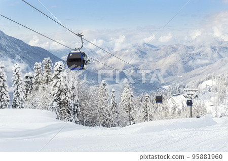 New modern spacious big cabin ski lift gondola against snowcapped forest tree and mountain peaks covered in snow landscape in luxury winter alpine resort. Winter leisure sports, recreation and travel 95881960