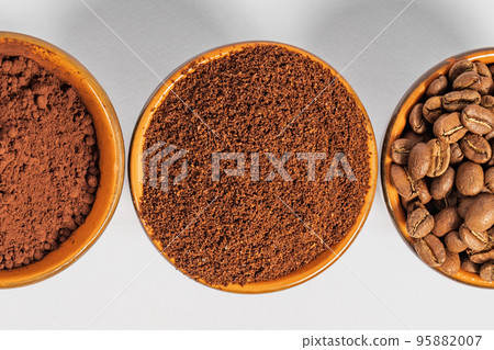 three small saucers with coffee beans, ground coffee and cocoa on a white background. three small saucers with coffee beans, ground coffee and cocoa on a white background. 95882007