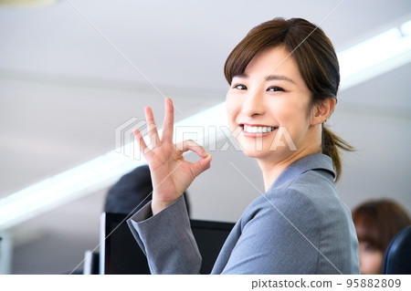 A young business woman in a suit working in the office (okay) A young business woman in a suit working in the office (okay) 95882809