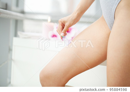 Woman getting anti-cellulite massage of leg with use of vacuum cans 95884598