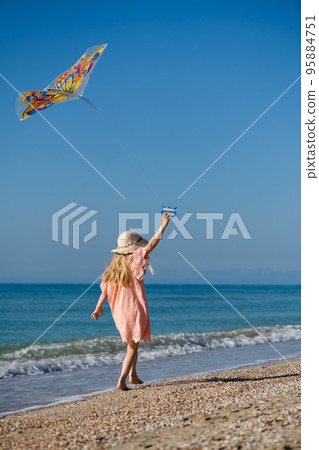 Little girl walk with kite at beach 95884751