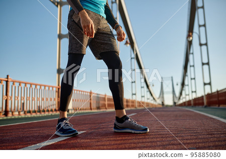 Sports background with male runner feet on bridge road 95885080