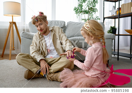 Daughter painting father nails with nail polish Daughter painting father nails with nail polish 95885198