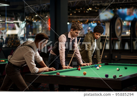 Company of handsome young guy playing in pool 95885294