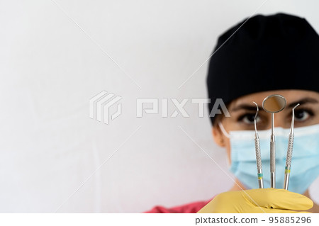 young female dentist holding dental instruments in her hand young female dentist holding dental instruments in her hand 95885296