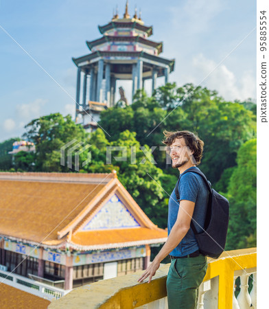 Young man tourist in Buddhist temple Kek Lok Si in Penang, Malaysia, Georgetown Young man tourist in Buddhist temple Kek Lok Si in Penang, Malaysia, Georgetown 95885554