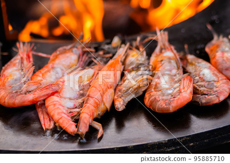 Process of cooking fresh red langoustine shrimps, prawns on grill - street food 95885710