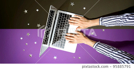Person using a laptop computer with small stars Person using a laptop computer with small stars 95885791