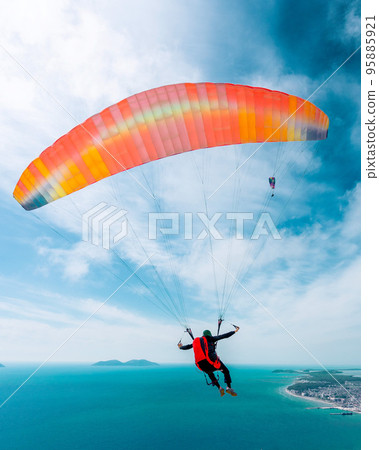 Paraglider is starting. Parachute is filling with air in the mountains alps on a sunny day in albania 95885921