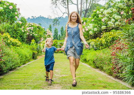 Mom and son are running around in the blooming garden. Happy family life style concept 95886366