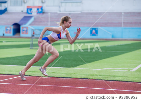 Young caucasian woman is engaged in jogging at the stadium outdoors. Young caucasian woman is engaged in jogging at the stadium outdoors. 95886952
