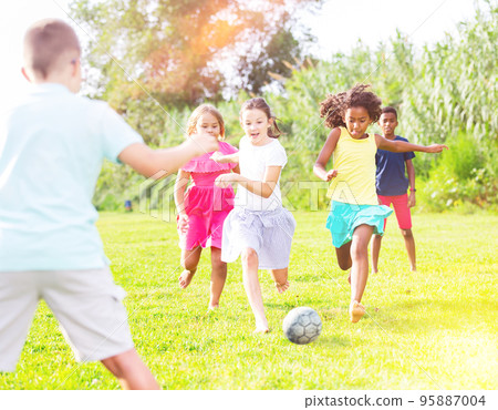 Group of kids playing football on grass Group of kids playing football on grass 95887004