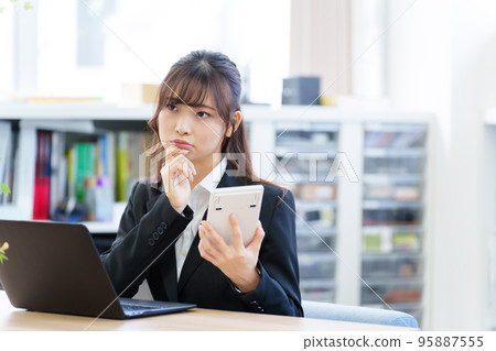 Business woman thinking with a calculator 95887555