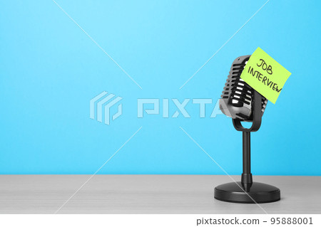 Retro microphone and reminder note with words JOB INTERVIEW on wooden table against light blue background, space for text Retro microphone and reminder note with words JOB INTERVIEW on wooden table against light blue background, space for text 95888001