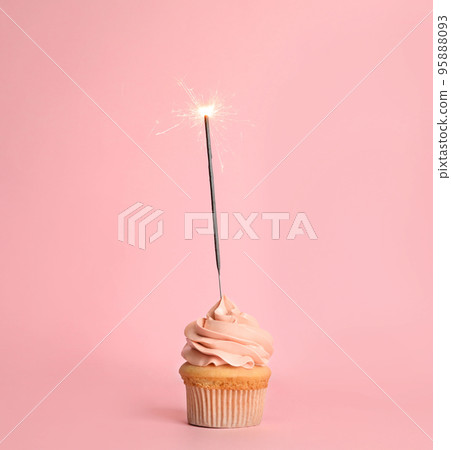 Birthday cupcake with sparkler on pink background Birthday cupcake with sparkler on pink background 95888093
