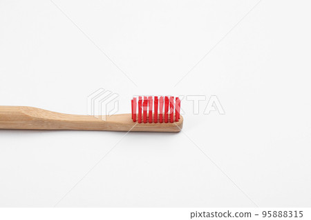 Bamboo toothbrush with red bristle isolated on white Bamboo toothbrush with red bristle isolated on white 95888315
