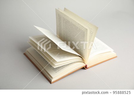 Open old hardcover book on light grey background 95888525
