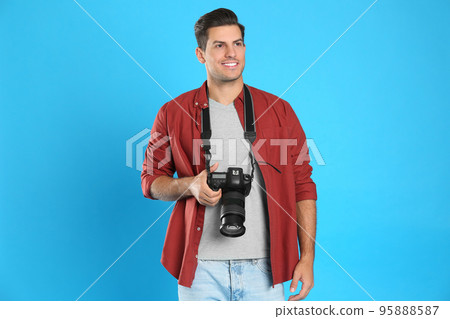 Professional photographer working on light blue background in studio Professional photographer working on light blue background in studio 95888587