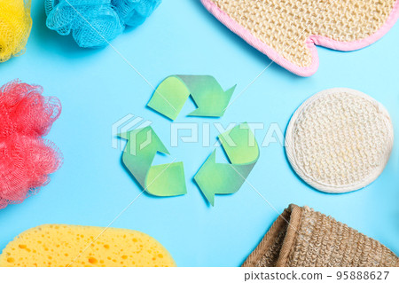 Recycling symbol, plastic and natural shower sponges on light blue background, flat lay 95888627