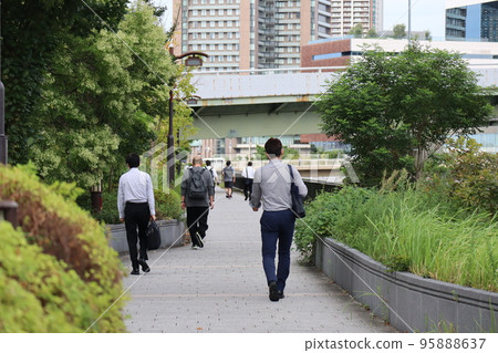 早上在城市沿河的長廊散步的通勤者的風景 95888637
