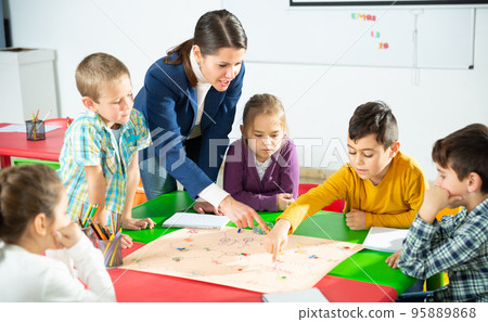 Kids and teacher playing educational board game 95889868