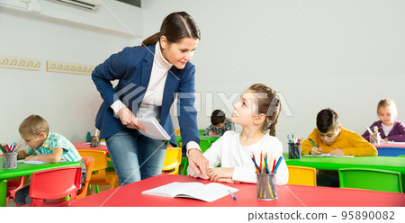 Teacher woman helping children during lesson 95890082