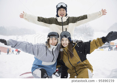 Group enjoying snowboarding with friends 95890159