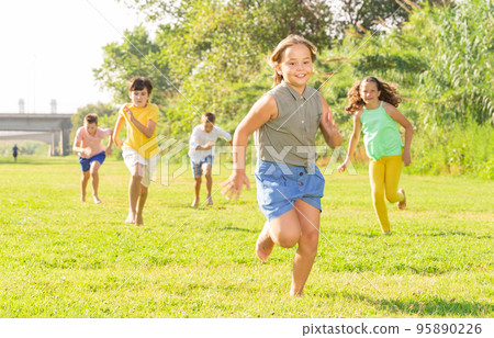 Children running on green grass 95890226