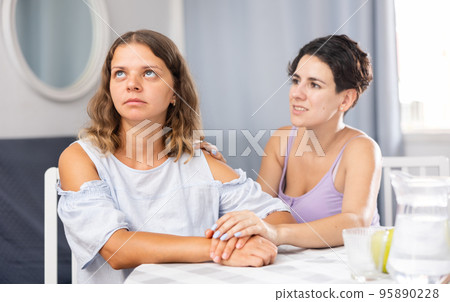 Frustration woman sitting at home and her partner asking to forgive after argument 95890228