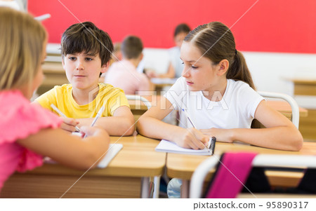 Tweens working in small groups during lesson at school 95890317